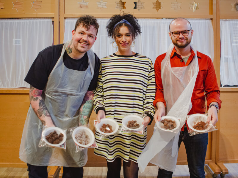 People in a chocolate making class show off their truffles.
